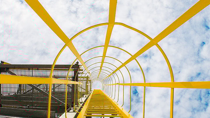 kuva keltaisista tikkaista teollisuusalueella